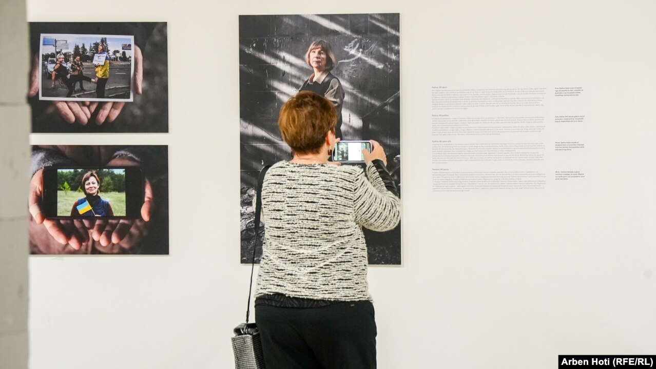 Një grua fotografon një nga punimet e paraqitura në ekspozitën "Ukraina: Një krim lufte". Përshkrimi i secilës fotografi të paraqitur në ekspozitë ishte në gjuhën shqipe, serbe, angleze dhe ukrainase.