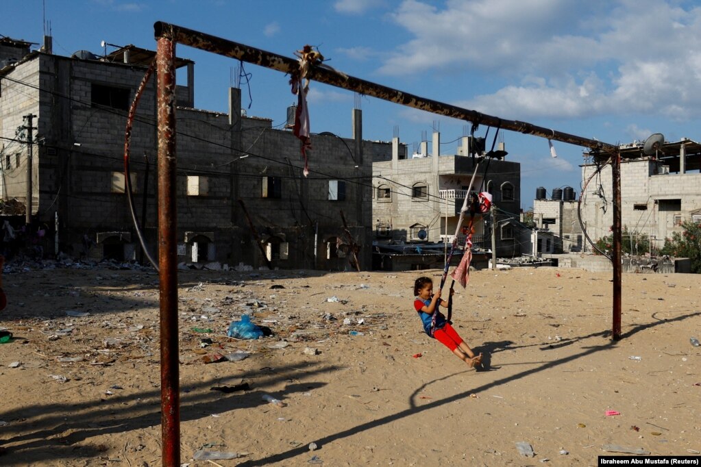 Një fëmijë duke u luhatur mes ndërtesash të shkatërruara nga një sulm izraelit, në Khan Younis më 19 tetor 2023.