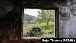 S prozora oštećene kuće tokom napada srpskih snaga u ratu 1999. vidi se travnjak na kome su ubijeni albanski civili sela Landovica.