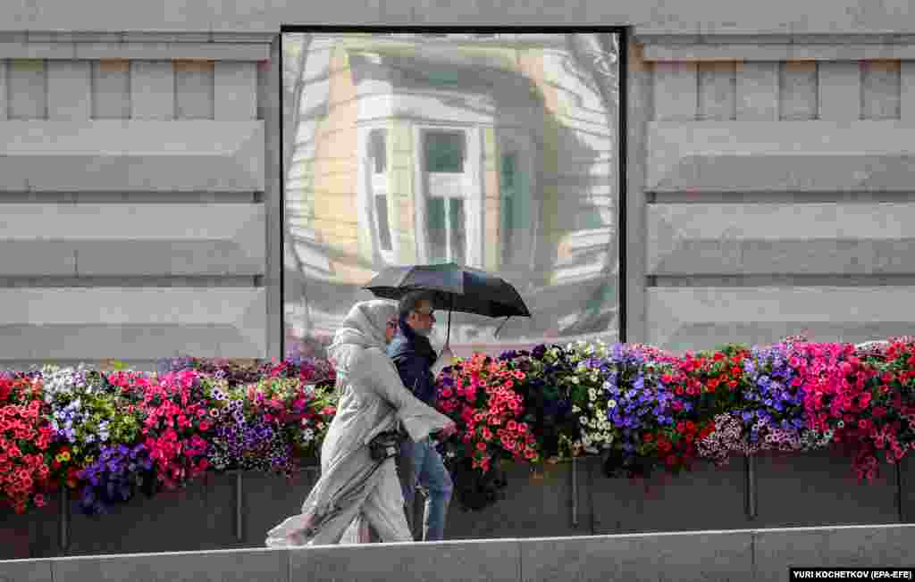  People walk along flower decorations as part of an urban landscape design festival in front of the Kremlin in Moscow, amid Russia&#39;s ongoing invasion of Ukraine. 