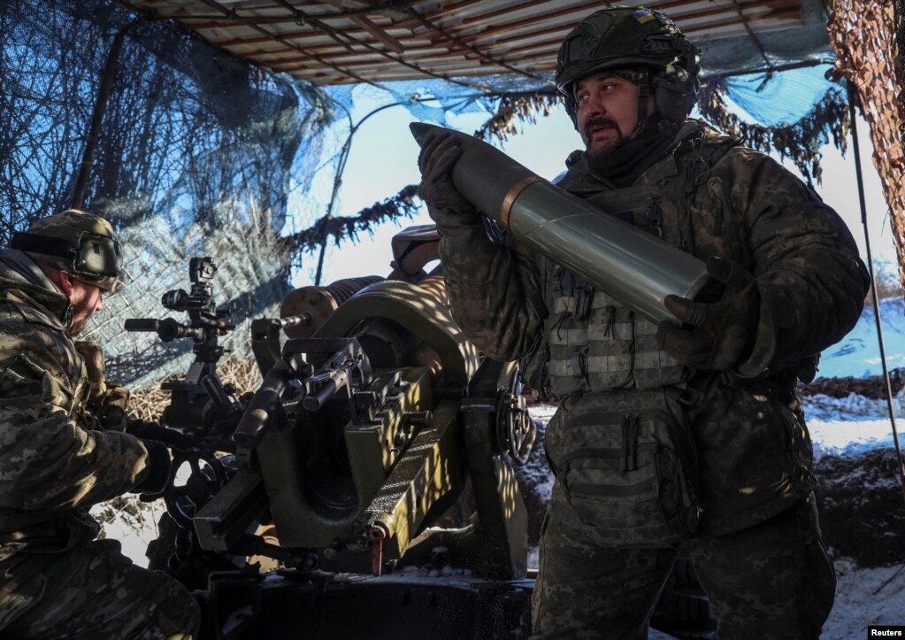 Anëtarët e shërbimit ukrainas të brigadës së 79-të duke mbushur me municion një obus L119 për të qëlluar drejt forcave ruse në rajonin e Donjeckut, Ukrainë, 12 janar 2024.