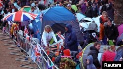 Ljudi čekaju na procesiju kraljevske povorke od Bakingemske palate do Vestminsterske opatije, London, 6. maj 2023.