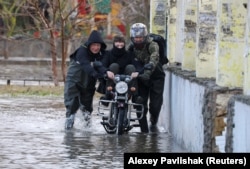 Люди йдуть затопленою вулицею Євпаторії, 27 листопада 2023 року