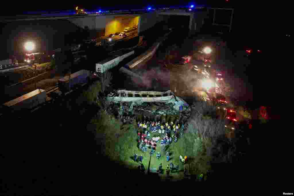 Ekipet e shpëtimit shihen duke punuar gjatë natës në vendin e aksidentimit të dy trenave.