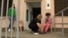 NORTH MACEDONIA -- VILLAGE TIMJANIK Social worker helping Adelina to get dressed