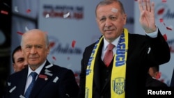 Президент Туреччини, лідер Партії справедливості та розвитку Тайїп Ердоган (праворуч) вітає своїх прихильників під час мітингу у зв'язку з майбутніми місцевими виборами в Анкарі, Туреччина, 23 березня 2019 року