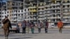 Робітники на тлі будівництва багатоповерхівки в окупованому Маріуполі. Ілюстративне фото