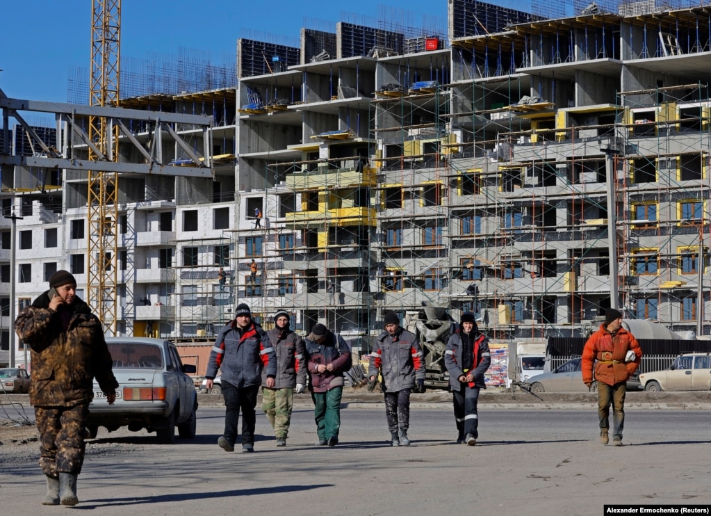 Punëtorët ndërtimi në Mariupol. Sipas OKB-së, deri në 90 për qind të ndërtesave të banimit të qytetit u dëmtuan ose u shkatërruan gjatë rrethimit rus.
