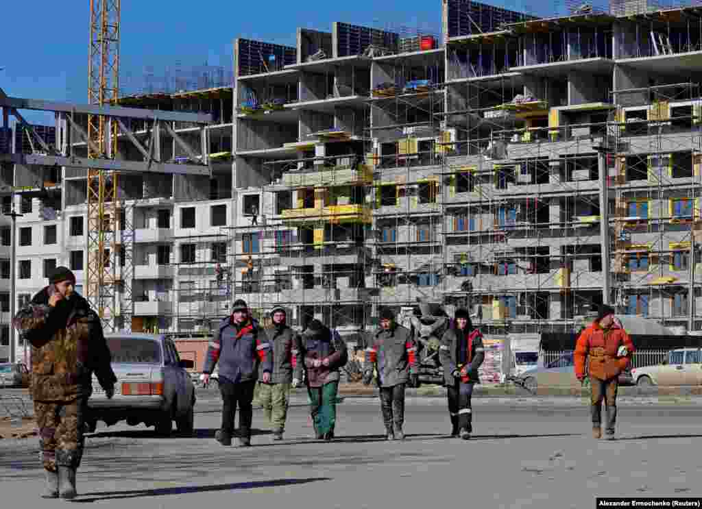 Робітники на будівельному майданчику в Маріуполі. 10 лютого 2023 року. За даними ООН, під час російської облоги були пошкоджені або знищені до 90 відсотків житлових будинків міста