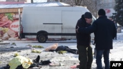Мужчина плачет у тел погибших от обстрела рынка в микрорайоне Текстильщик в оккупированном Донецке, 21 января 2024 года
