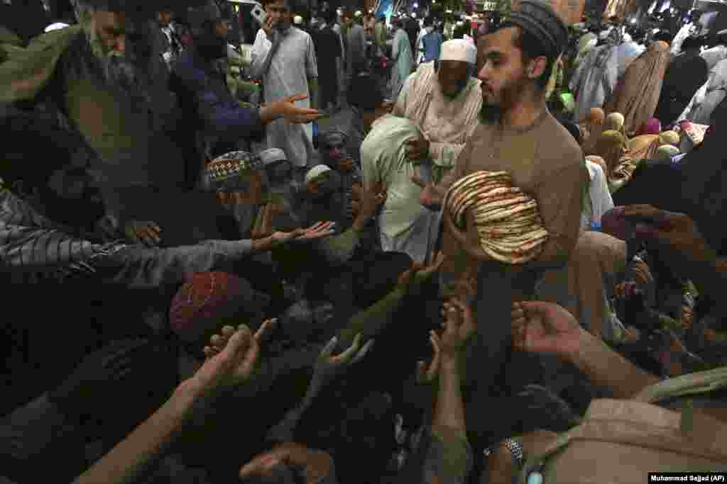 A worker distributes free traditional roti or bread among needy people at a restaurant in Peshawar on April 16. According to the Global Hunger Index 2021, Pakistan ranks 92nd out of 107 countries, indicating a &quot;serious&quot; level of hunger. The government of Pakistan has launched several initiatives to address food insecurity; however, it remains a significant challenge. &nbsp;