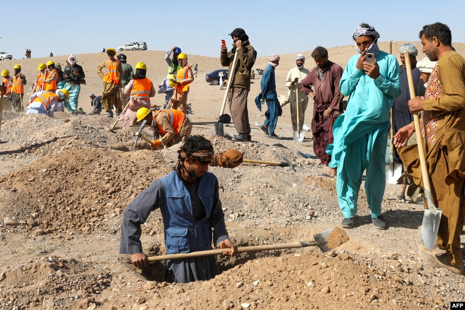 Afghans dig graves for earthquake victims. The WHO has put the number of those affected at more than 11,000 people.