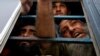 Afghan nationals, who, according to police, were undocumented, spoke to the members of the media from the window of a bus as they were detained in Karachi, Pakistan, on November 2.