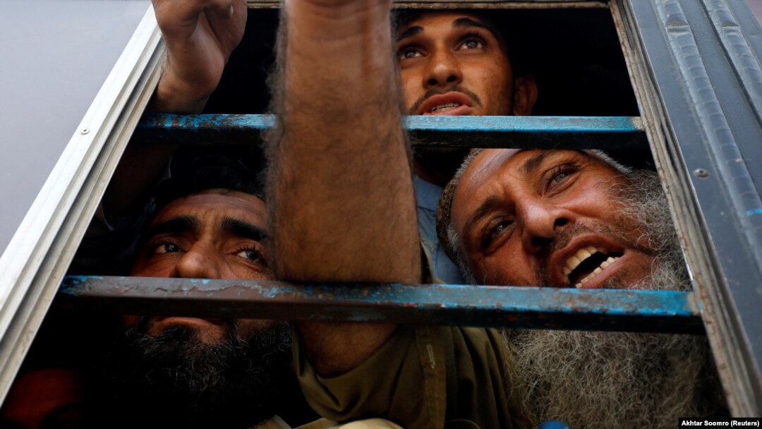 Afghan nationals, who, according to police, were undocumented, spoke to the members of the media from the window of a bus as they were detained in Karachi, Pakistan, on November 2.