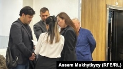 Айтбек Амангельды (слева), адвокат Жанна Уразбахова и другие представители потерпевшей стороны у зала суда, Астана, 11 марта 2024 года