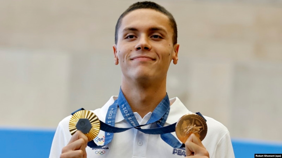 David Popovici pozează cu medaliile de aur și bronz câștigate la Jocurile Olimpice de la Paris, la întoarcerea sa din Franța, la Aeroportul Internațional Otopeni, 2 august 2024.