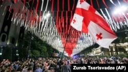 Demonstrators waving a giant Georgian national flag gather at the parliament building during an opposition protest against the "foreign agents" law in Tbilisi, Georgia. (file photo)