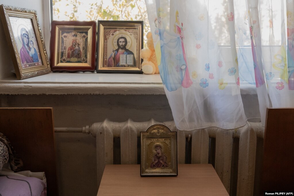 Le icone religiose di una famiglia adornano la stanza in cui vivono nel centro di accoglienza per rifugiati.  Mentre alcune famiglie fuggono da Kherson, altre hanno scelto di restare.   