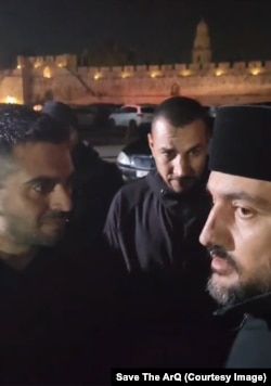 Men linked to XANA Capital (left) speak with a Jerusalem Armenian priest. Several confrontations have taken place since the Patriarchate stated its intention to cancel the agreement.