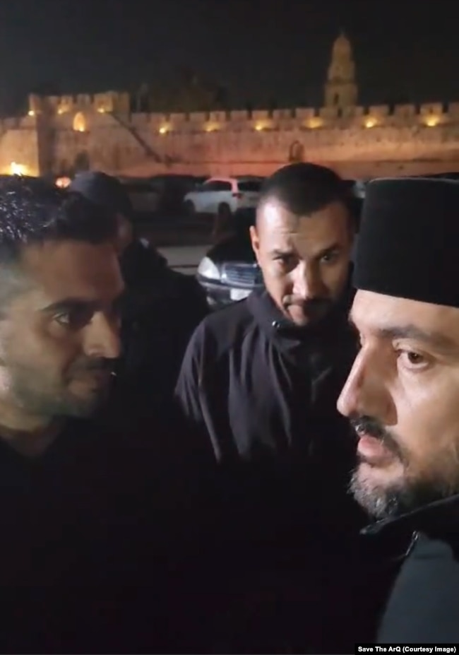 Burra të lidhur me XANA Capital (majtas) duke biseduar me një prift armen në Jerusalem. Disa konfrontime kanë ndodhur që kur Patrikana ka shprehur synimin e saj për anulimin e marrëveshjes.