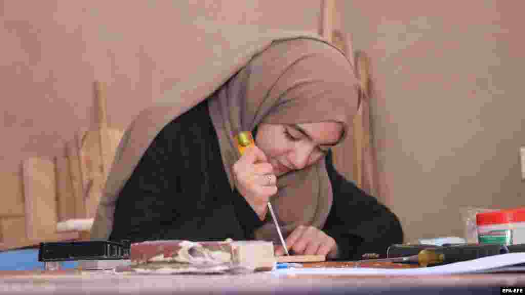 Egy lány nurisztáni faragványokat készít egy műhelyben az afganisztáni Herátban 2023 novemberében