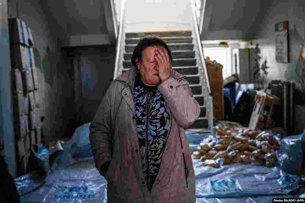 Olena Archipenko, 62, reacts as she prepares bread to be distributed to her neighbors in Siversk, in Ukraine&#39;s eastern Donetsk region.