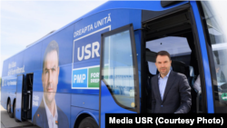 Fostul președinte USR, Cătălin Drulă, în campania de la alegerile locale din iunie 2024 coboară dintr-un autocar colantat cu imaginea sa și cu mesajul electoral „Nu-i lăsa să îți fure viitorul”.