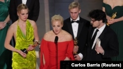 Yulia Navalnya speaks next to her daughter Daria and director Daniel Roher (right) at the Oscars on March 12.