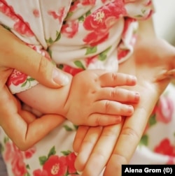 A Maryinka mother with the hand of her baby in 2018.