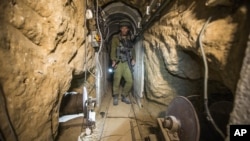 Офицер от израелската армия прави обиколка с журналисти на границата между Израел и Газа, петък, 25 юли 2014 г., в тунел, за който се предполага, че е използван от палестински бойци за нападения срещу Израел. 