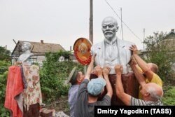 Bărbații din regiunea Donețk ocupată de ruși instalează un bust al lui Vladimir Lenin în iulie.