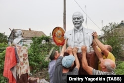 Men in the Russian-occupied Donetsk region install a bust of Vladimir Lenin in July.