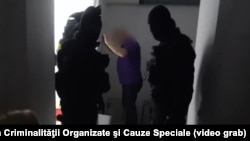 Moldovan anti-corruption officials detain a suspect in a treason and conspiracy case (video grab).
