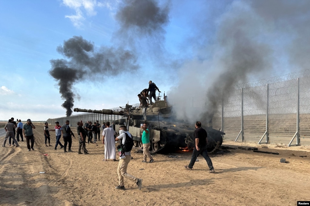 Palestinezët grumbullohen afër një tanku të ushtrisë Izraelite që u shkatërrua nga një sulmues palestinez që u infiltrua në jug të Izraelit, pranë kufirit me Izraelit dhe Gazës. 