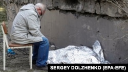 ფოტო არქივიდან: ნათესავი ზის 9 წლის გოგოს ცხედართან, რომელიც კიევის დაბომბვას ემსხვერპლა უკრაინა. 2023 წლის 1 ივნისი