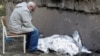 Bunicul veghează trupul acoperit al fetițe care a fost ucisă în urma unui atac cu rachete rusești asupra Kievului la 1 iunie. 