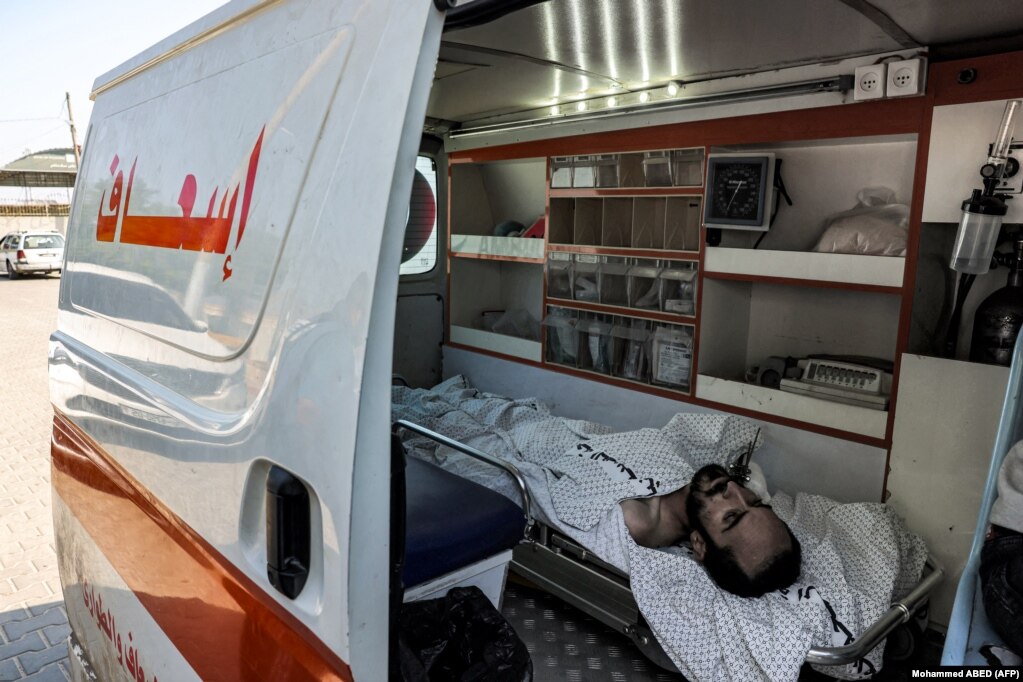 Një burrë i plagosur qëndron shtrirë brenda një autoambulance në pikën kufitare Rafah më 1 nëntor 2023.