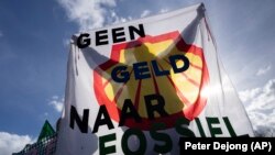 Protesti grupe Extinction Rebellion sa transparentom na kom piše "Ne novcu za fosilna goriva" u Hagu, 11. marta