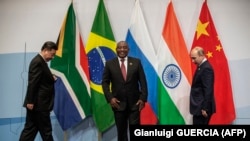 Președintele Chinei, Xi Jinping, președintele Africii de Sud, Cyril Ramaphosa, și președintele Rusiei, Vladimir Putin, se pregătesc pentru o fotografie de grup în timpul summitului BRICS din iulie 2018, Johannesburg, Africa de Sud