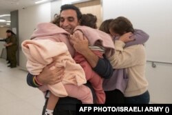  Мъж посреща брачната половинка и дъщерите си, които са били арестувани кто заложници от Хамас. 