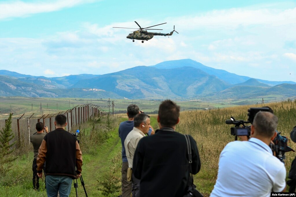 Un gruppo internazionale di giornalisti filma un'operazione delle forze di pace russe.  elicottero militare mentre sorvola un campo appena fuori Xankendi il 2 ottobre. Le autorità armene hanno accusato le forze di pace russe dispiegate nel Nagorno-Karabakh dopo la guerra del 2020 di essere rimaste a guardare e di non riuscire a fermare l'assalto azerbaigiano.  Mosca ha respinto le accuse, sostenendo che le sue truppe non avevano il mandato per intervenire.