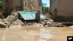 مردی در بغلان در کنار ویرانه‌های ناشی از سیلاب