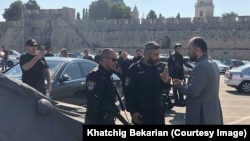 Israeli police speak with an ethnic Armenian priest in Jerusalem's Cow's Garden. 
