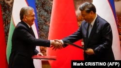Председатель Китая Си Цзиньпин (справа) и президент Узбекистана Шавкат Мирзиеев на церемонии подписания на полях саммита Китай – Центральная Азия в Сиане, провинция Шэньси, 18 мая 2023 года