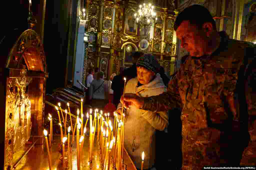 Люди запалюють свічки&nbsp;під час Великодніх богослужінь у Михайлівському соборі. Київ, 5 травня 2024 року