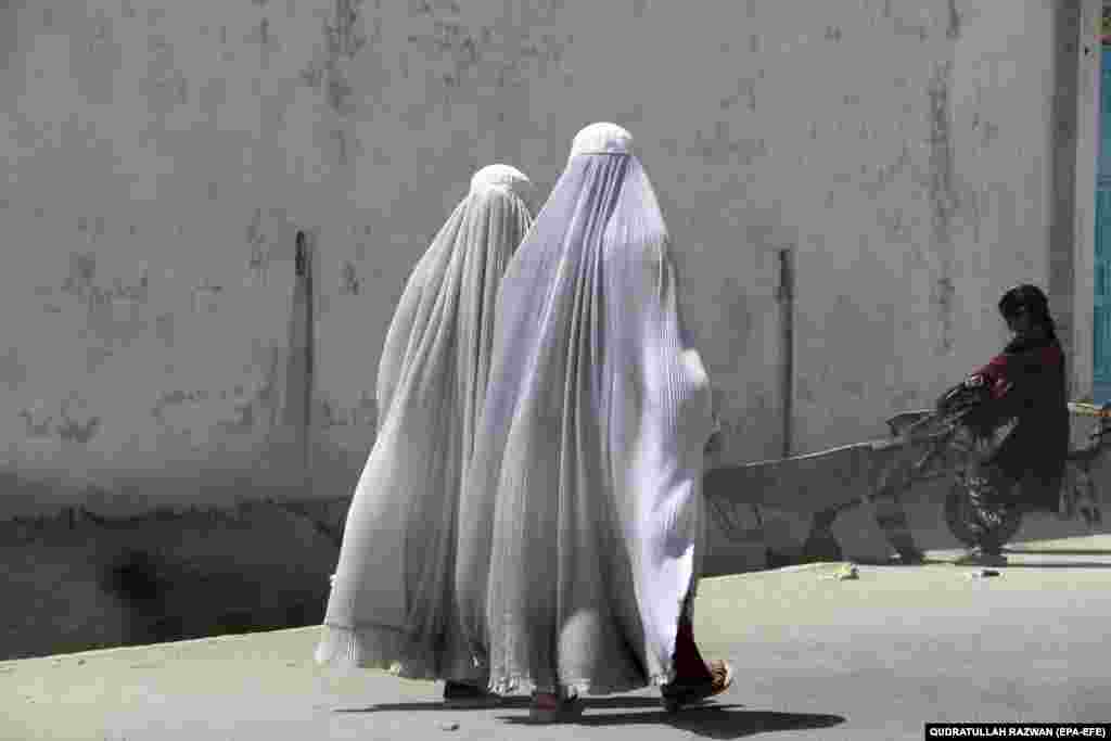 &nbsp;Burqa-clad Afghan women walk on a road in Kandahar, Afghanistan.