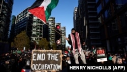 Протестующие с плакатами и флагами принимают участие в «Национальном марше за Палестину» в центре Лондона 11 ноября 2023 года, призывая к прекращению огня в конфликте между Израилем и ХАМАС