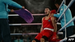 A Kazakh boxer catches his breath between rounds at a match during the Paris Olympics.