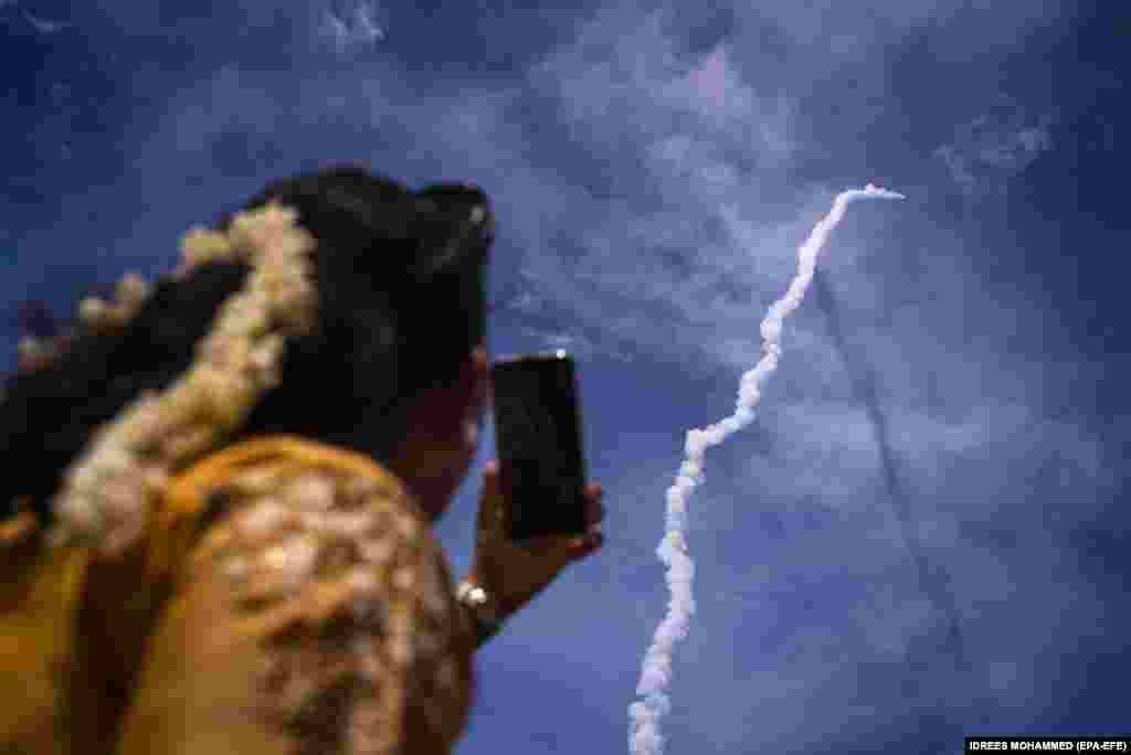 Представник громадськості спостерігає за тим, як апарат Chandrayaan-3 (Місяцехід-3) Індійської організації космічних досліджень (ISRO) на борту ракети-носія Mark-III Mission 4 (LVM3 M4) стартує з Космічного центру імені Сатіша Давана в Шріхарікоті, в південному штаті Андхра-Прадеш. Індія, 14 липня 2023 року. Індійське космічне агентство з бюджетом менше від 75 мільйонів доларів намагається висадити місяцехід на Місяць. (EPA-EFE/IDREES MOHAMMED)
