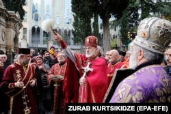 A Georgian Orthodox priest blesses the congregation during a service marking the Day of St. George at a church in Tbilisi.